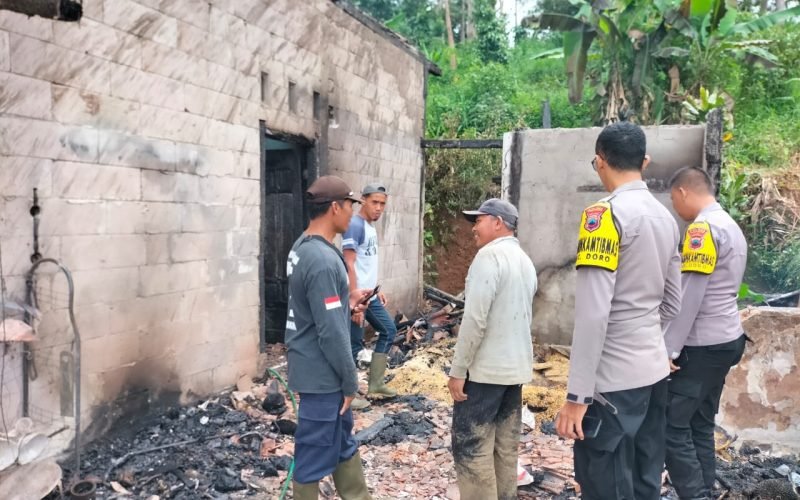 Petugas polisi saat melakukan olah TKP dirumah yang terbakar (dok. Humas)