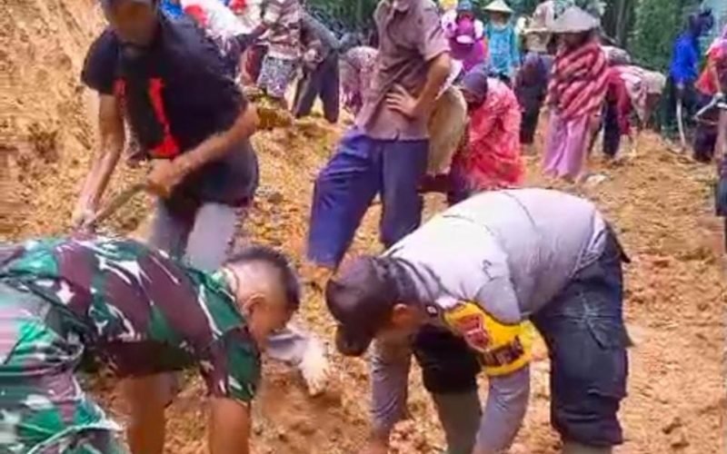 GOTONG ROYONG - Warga dan TNI-Polri bersama-sama membersihkan sisa material yang menutup jalan akibat tanah longsor (dok. Humas)