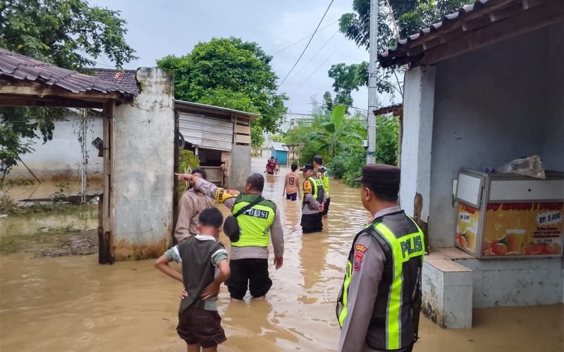 Petugas kepolisian melakukan pemantauan di kawasan permukiman yang terendam banjir akibat hujan deras di Kecamatan Kedungwuni, Kabupaten Pekalongan, Jumat (23/1/2026).