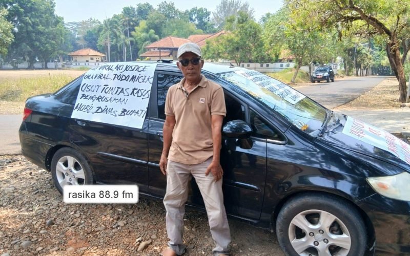Ketua LSM Forum Masyarakat Pekalongan Bersatu (FMPB), Mustofa Amin, berdiri di depan mobil aksi yang dipasangi sejumlah tulisan bernada protes, Rabu (14/10/2026). Aksi tersebut menjadi bentuk desakan agar kasus pengrusakan mobil dinas Bupati Pekalongan diusut tuntas dan pelakunya segera ditangkap (dok. Bagus - Rasika FM Pekalongan)