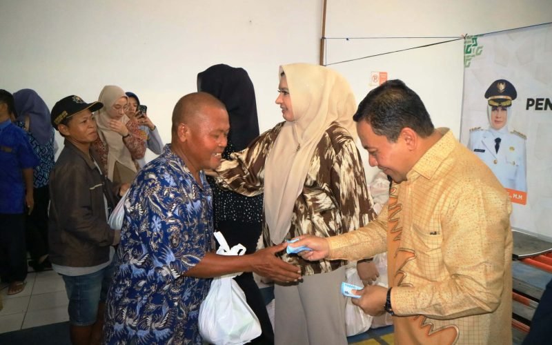 Bupati Fadia dan Wabup. Sukirman saat membagikan bantuan pangan kepada juru parkir (27/03/2025 - dok. Bagus Rasika FM)