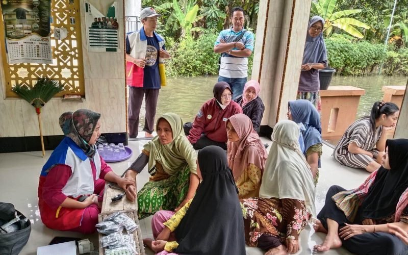 etugas kesehatan memberikan layanan pemeriksaan kepada warga terdampak banjir di salah satu posko kesehatan Kabupaten Pekalongan, Senin (19/1/2026).