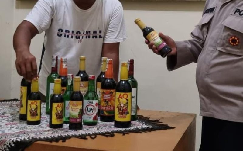 RAZIA - Petugas dari Polsek Kesesi Kabupaten Pekalongan menunjukkan barang bukti miras hasil razia 