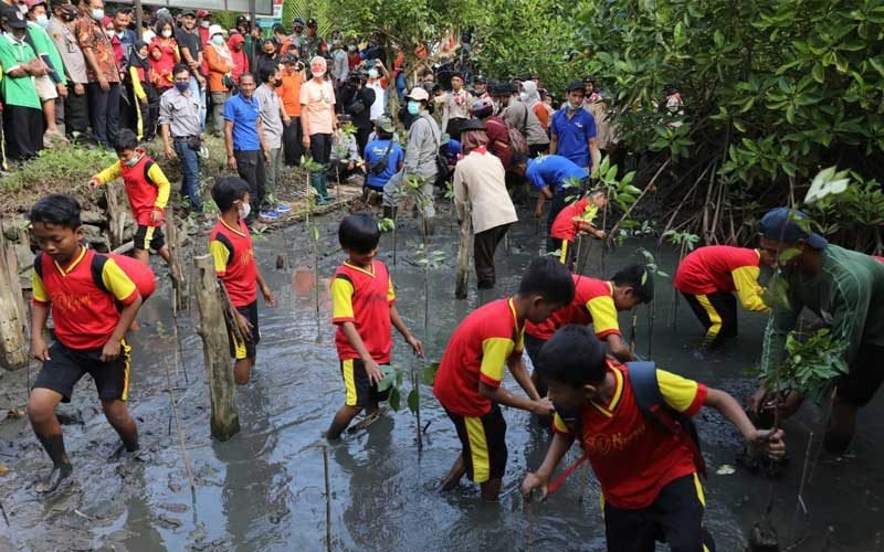 Gubernur Jawa Tengah Ganjar Pranowo menanam mangrove bersama pelajar, warga, dan aktivis lingkungan serta berkeliling Hutan Mangrove Muara Kali Ijo, Rabu (27/7/2022).