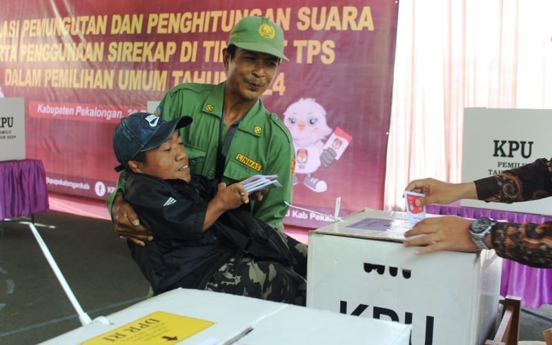 SIMULASI - Seorang penyandang disabilitas dibopong petugas hansip saat akan memasukkan surat suara usai menyalurkan hak pilihnya (26/12/2023 - dok. Bagus Rasika FM)
