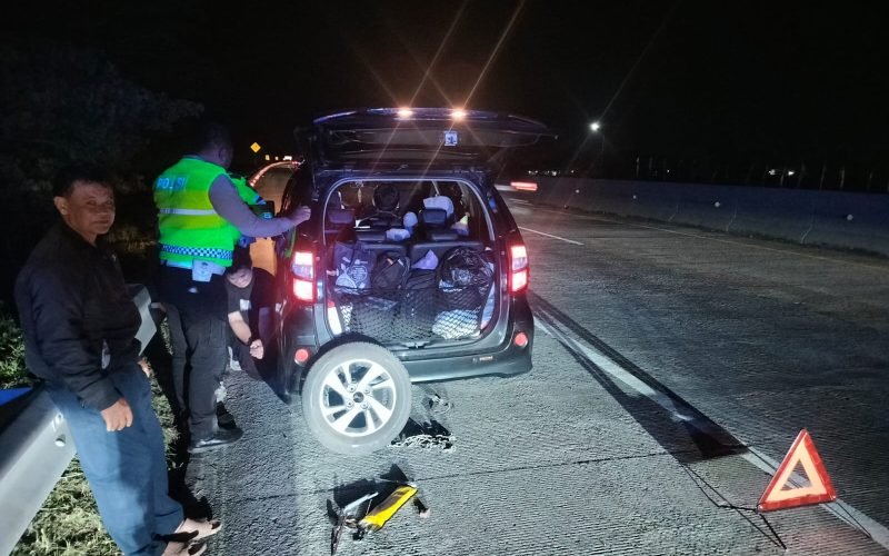 Petugas membantu pemudik yang mengalami pecah ban di ruas Tol Pemalang–Batang, Sabtu (27/12/2025) malam, agar kendaraan dapat kembali melanjutkan perjalanan dengan aman (dok. Istimewa)