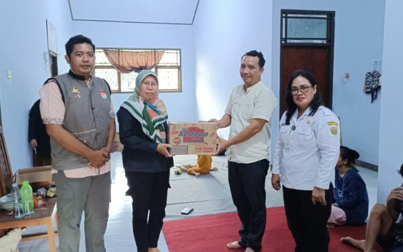 Ketua KPU Kabupaten Pekalongan, Laelatul Izah (dua dari kiri), menyerahkan bantuan logistik kepada perwakilan warga terdampak banjir di Posko Pengungsian Kecamatan Siwalan, Rabu (21/1/2026).