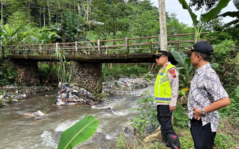 Kapolsek Kajen Iptu Teguh Subiyantoro melakukan pengecekan langsung di aliran Sungai Kalikarang yang tercemar sampah akibat longsoran TPA Bojonglarang, Kamis (22/1/2026).