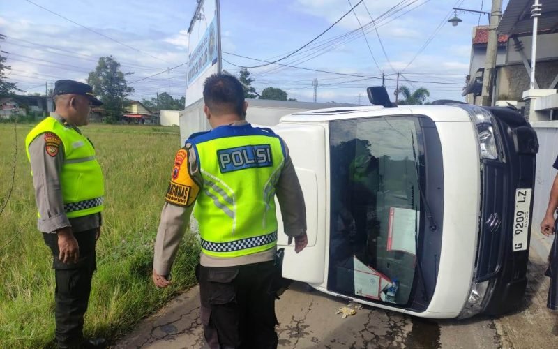 Petugas kepolisian memeriksa mobil operasional MBG yang terguling di Jalan Raya Pakisputih, Kedungwuni, usai insiden pada Jumat pagi (dok. Istimewa)